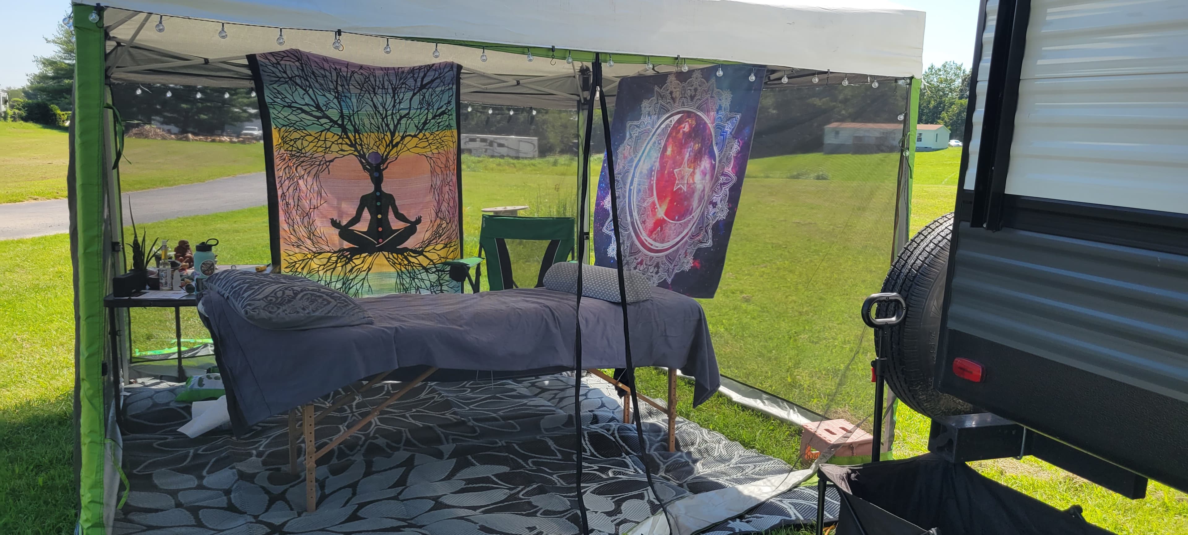 Outdoor healing session space with massage table under a canopy tent